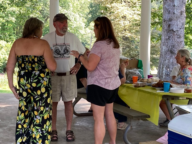 FOSA members standing and sitting, visiting with each other.